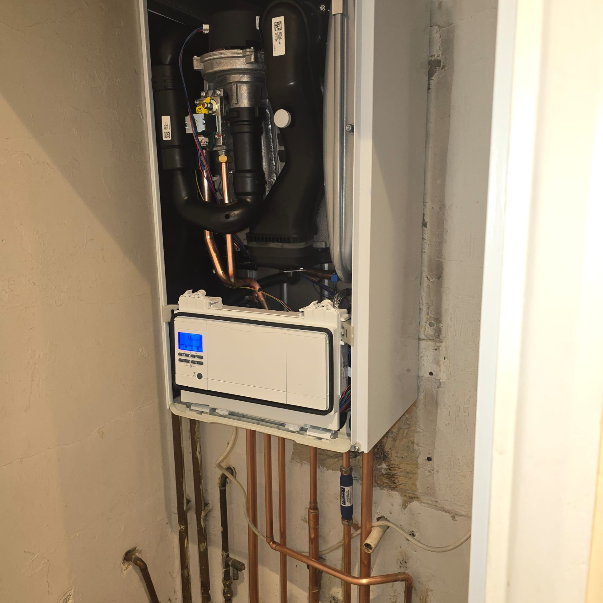 Vaillant boiler with the casing removed showing heat exchanger and wiring during commissioning